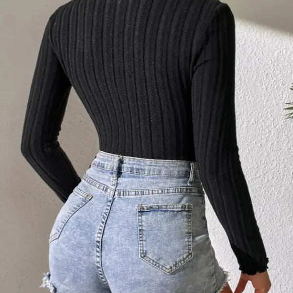 Woman wearing black ribbed turtleneck and denim shorts, showcasing Elegant Brushed Striped Jumpsuit