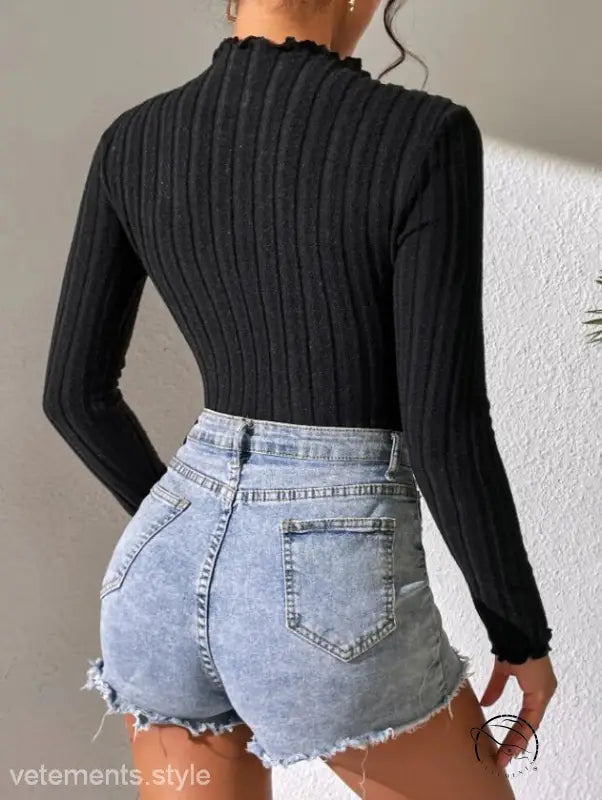Woman in brushed striped jumpsuit with turtleneck and denim shorts