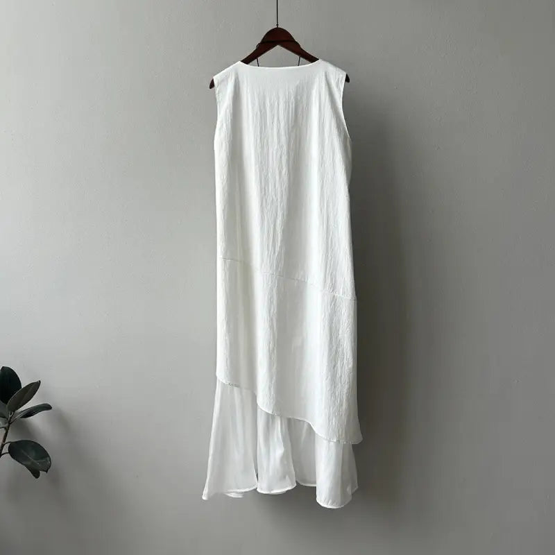 White sleeveless hem stitching dress with ruffled hem on a wooden hanger