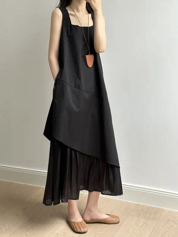 Asymmetrical black layered hem stitching dress with wide straps and elegant necklace