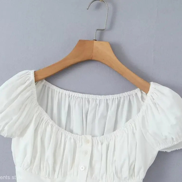 White puff-sleeve blouse on hanger from elegant casual skirt set, ideal for casual beach outfits