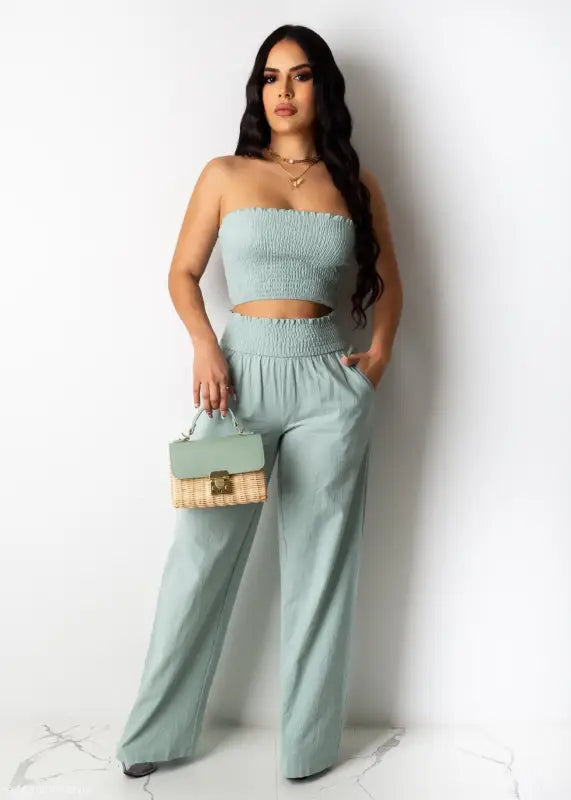 Woman in mint green strapless crop top and wide-leg pants, perfect for Berlin summer outfit