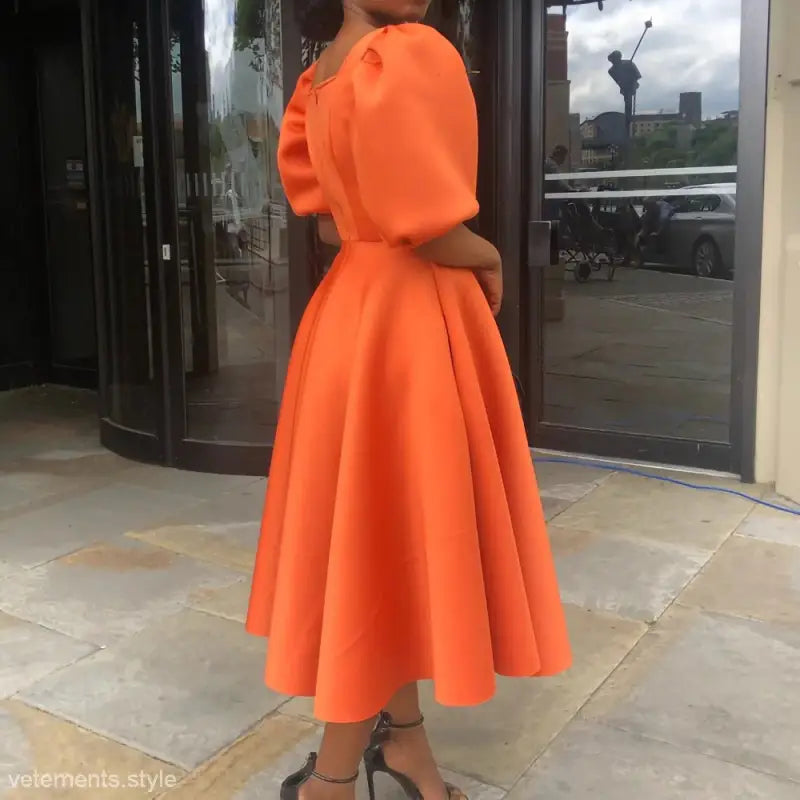 Elegant evening puff sleeve dress in vibrant orange with full skirt and puffed sleeves