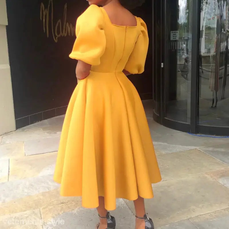 Elegant evening puff sleeve dress in bright yellow with a full skirt and puffed sleeves