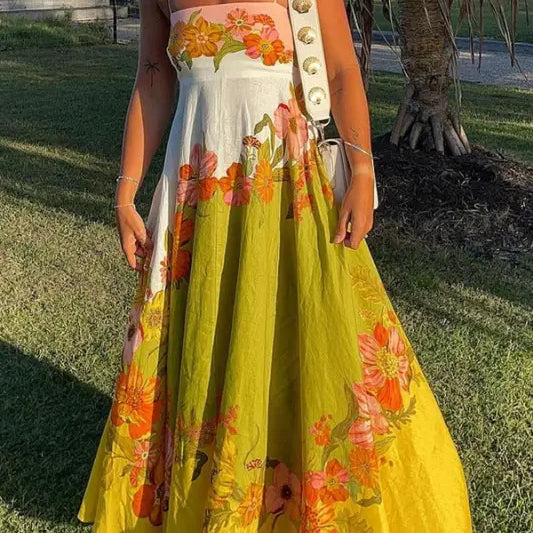 Colorful floral maxi dress with a white bodice and yellow skirt adorned with orange and pink flower patterns.