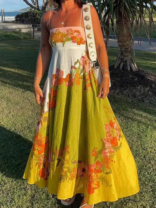 Colorful floral maxi dress with a white bodice and yellow skirt adorned with orange and pink flower patterns.