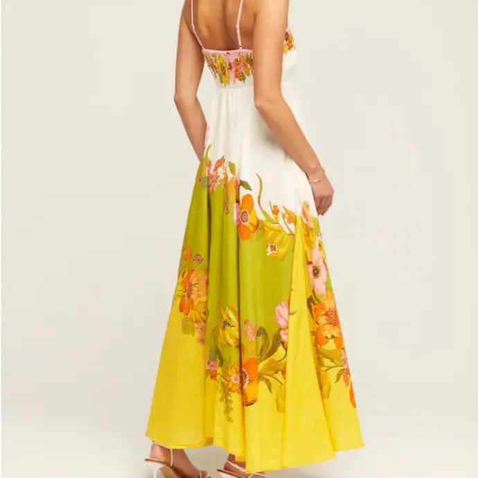 Floral maxi dress with a white bodice and yellow skirt featuring colorful flower prints.