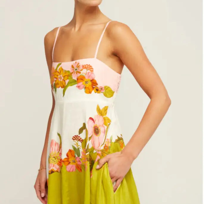 Floral sundress with spaghetti straps featuring a colorful pattern of flowers on a white, pink, and lime green background.