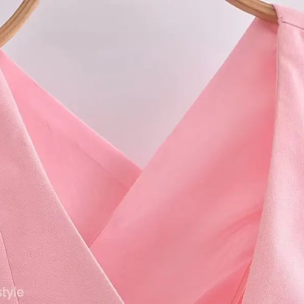 Pink v-neck top on hanger showcasing elegant French style sleeveless polyester design