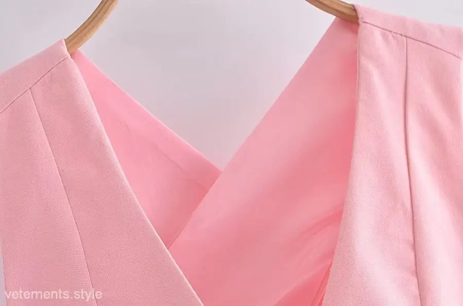 Pink v-neck top on hanger showcasing elegant French style sleeveless polyester design