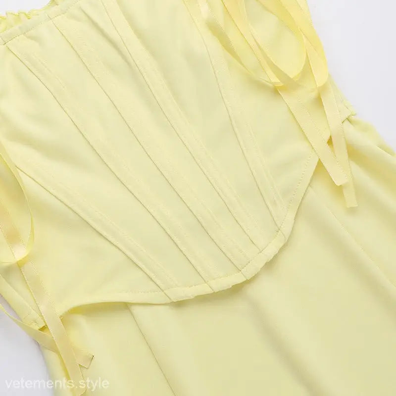 Pale yellow pleated fabric showcasing the Elegant Girdle Dress with Lace Accents
