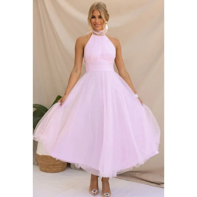 Woman in pink elegant halter evening dress made of mesh and lace for summer occasions