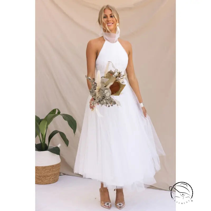Woman in elegant halter evening dress holding bouquet