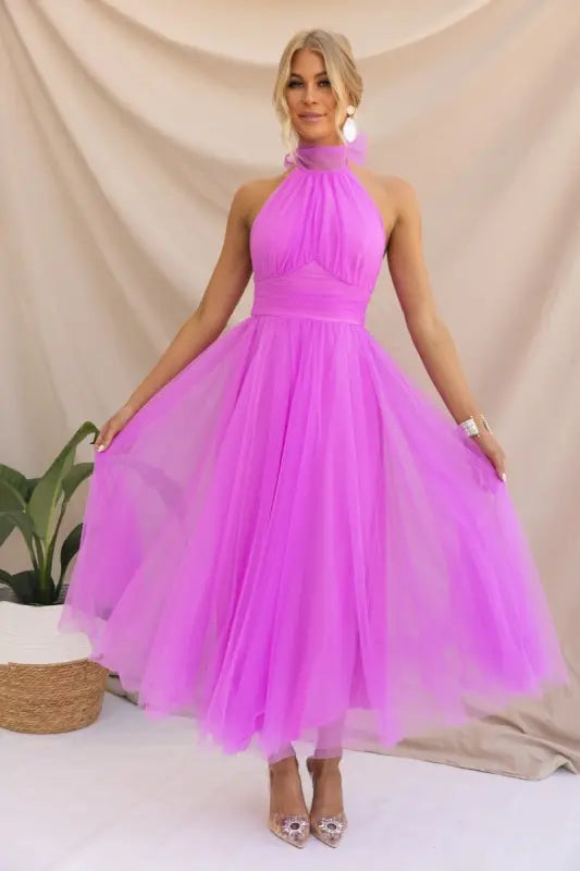 Woman in a bright pink tulle dress showcasing an elegant halter evening dress for summer occasions