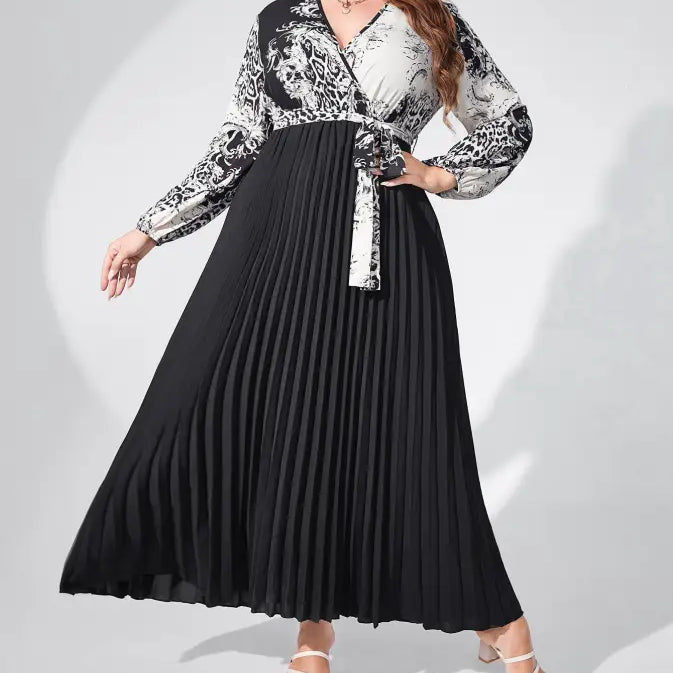 Long-sleeved maxi dress with a black pleated skirt and a white and black patterned top.