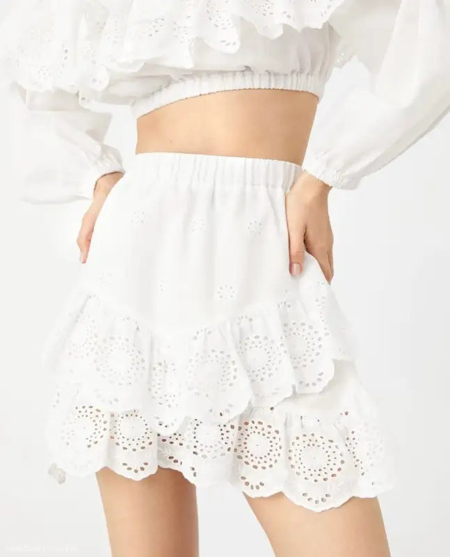 White eyelet lace mini skirt with ruffled hem and elastic waistband, ideal with jacquard ultra short crop tops