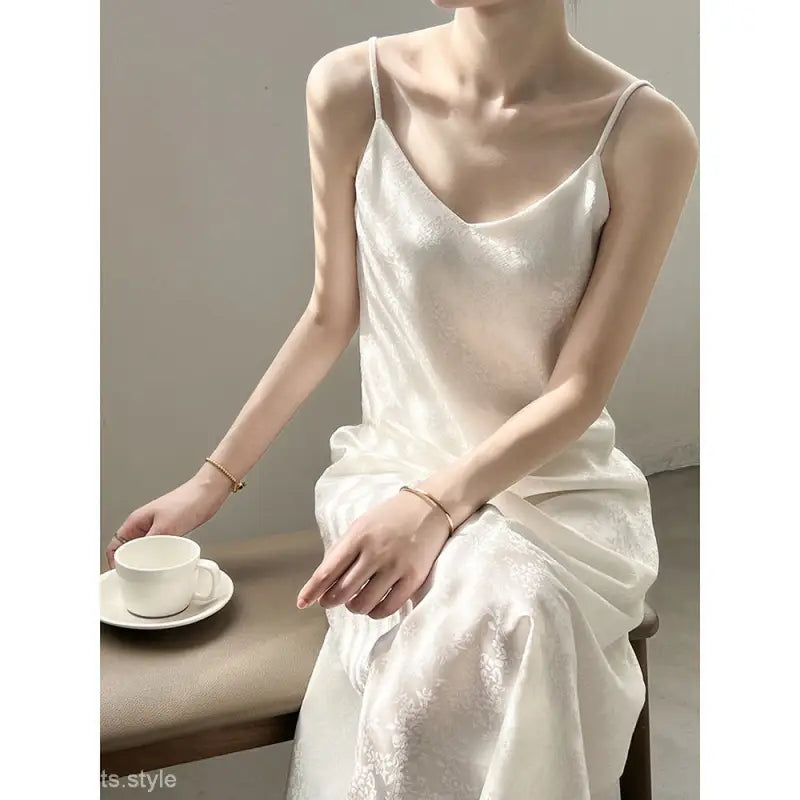 White satin slip dress with thin straps showcasing an elegant jacquard v-neck design