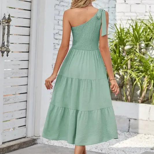 Woman wearing an elegant layered slit dress with shoulder pleated detailing