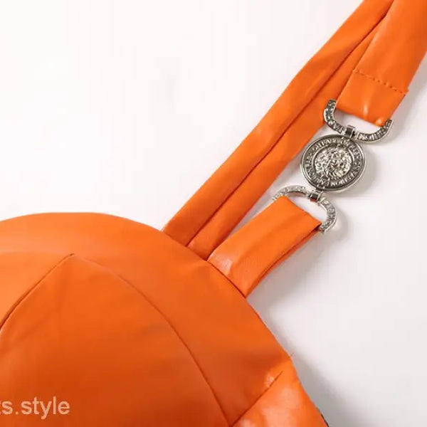 Elegant leather set featuring an orange leather chest wrap with decorative hardware and zipper hip skirt