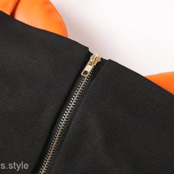 Elegant leather set featuring a black and orange zipper V-neck top and hip skirt