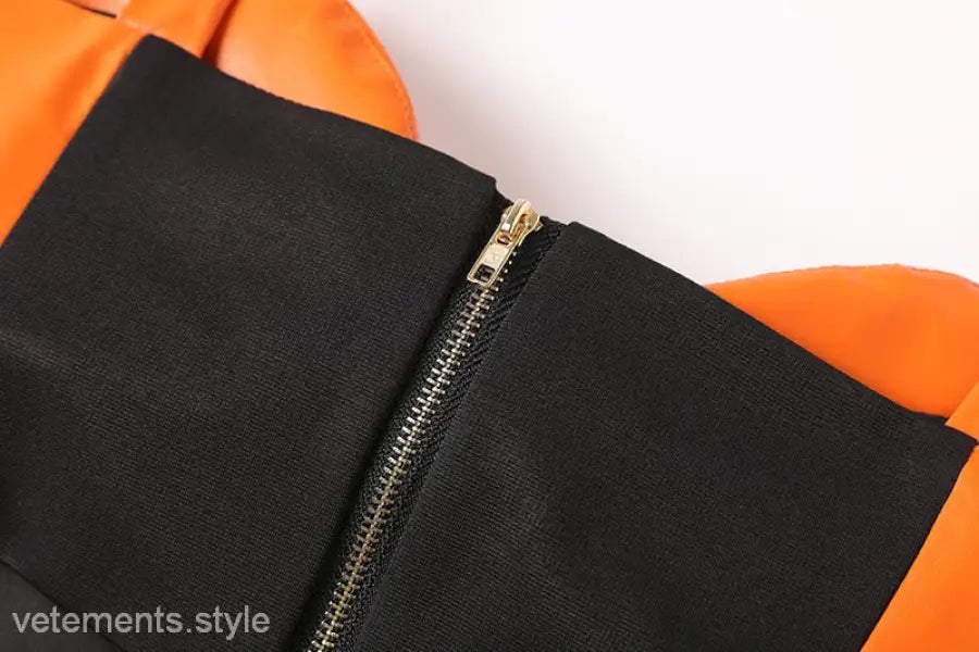 Elegant leather set featuring a black and orange zipper V-neck top and hip skirt