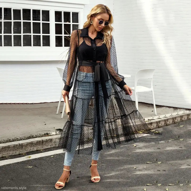 Woman in sheer polka dot summer mesh dress showcasing elegant long sleeve waist design