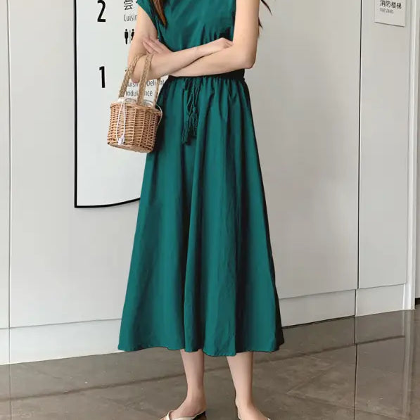 Sleeveless emerald green midi dress with a gathered waist and flowy skirt.
