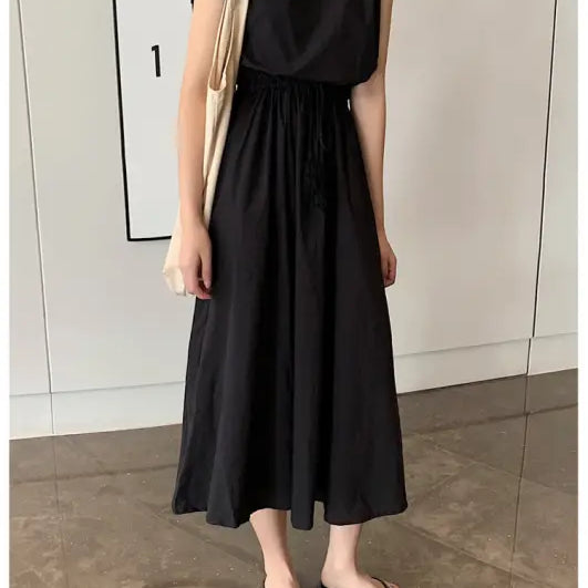 Black sleeveless maxi dress with a gathered waist and flowy skirt.