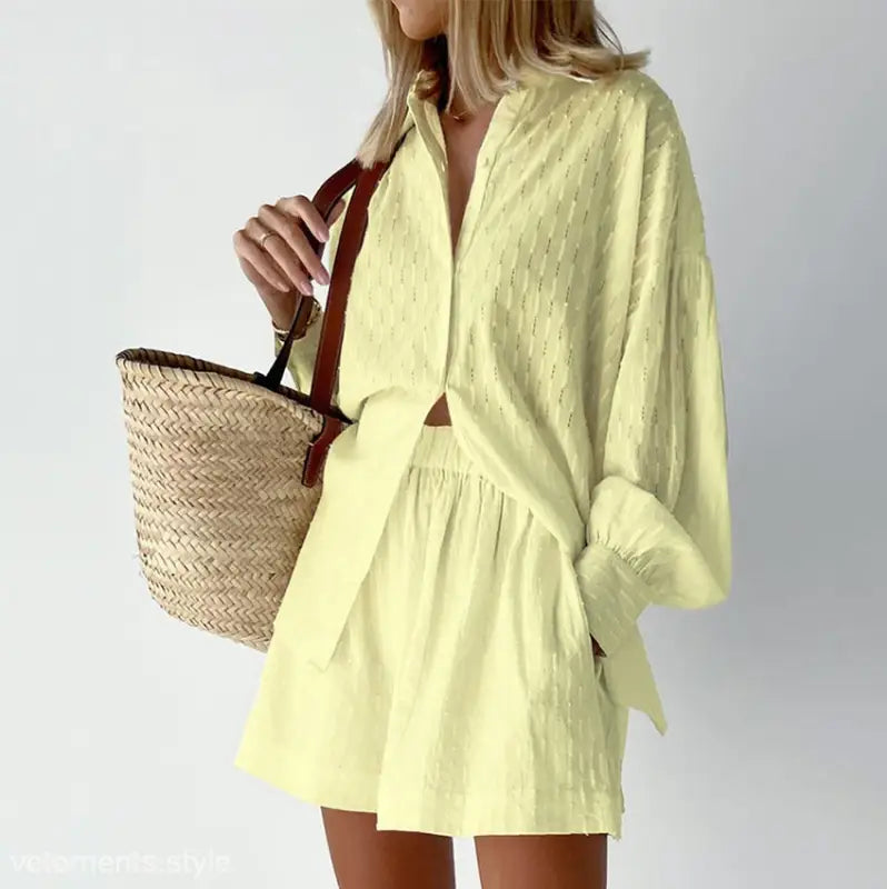 Yellow two-piece shorts office suit with elegant design and straw tote bag