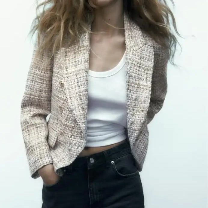 Textured beige loose houndstooth blazer styled over a white tank top and dark jeans