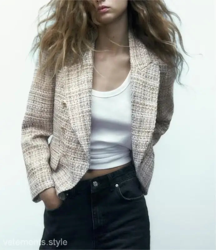 Textured beige loose houndstooth blazer styled over a white tank top and dark jeans