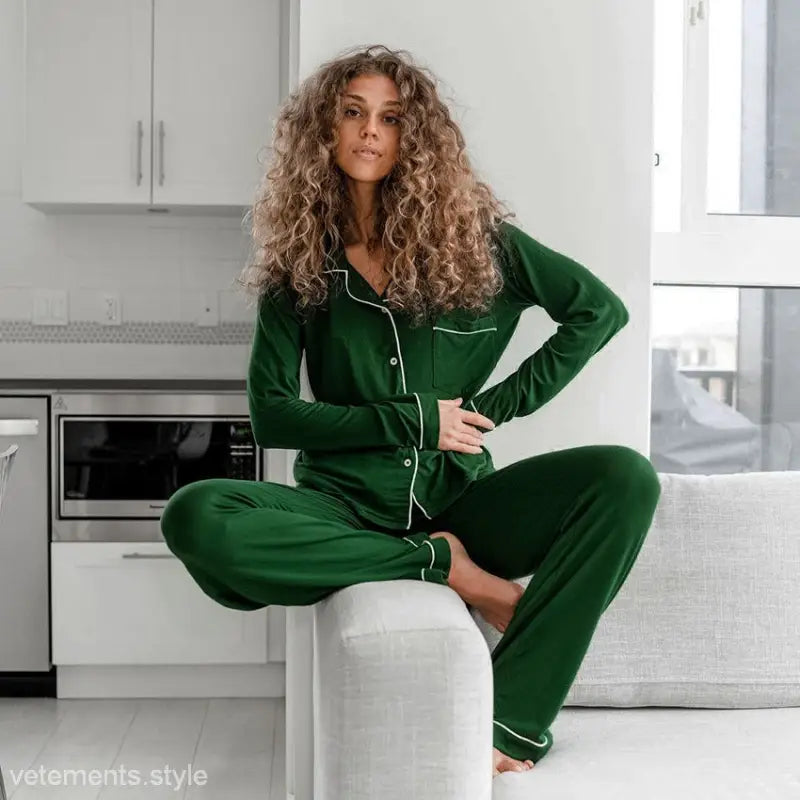 Woman in emerald green elegant loose pajamas seated in a kitchen for ultimate comfort