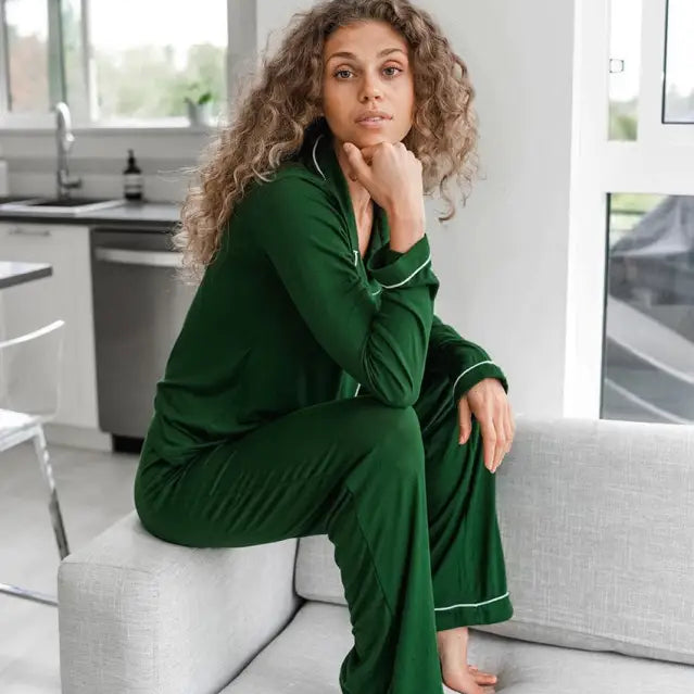 Woman with curly hair in elegant loose knitted pajamas sitting on a couch for ultimate comfort