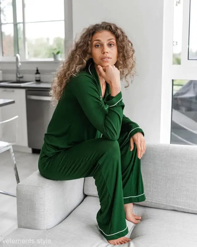 Woman with curly hair in elegant loose knitted pajamas sitting on a couch for ultimate comfort