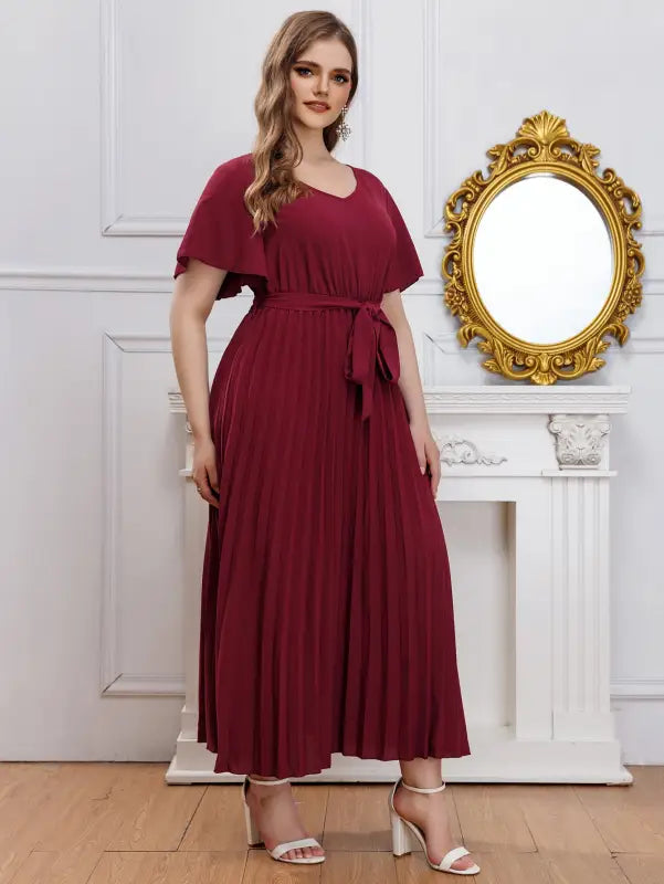 Plus-size maroon elegant loose pleated maxi dress with V-neck, flutter sleeves, and self-tie belt
