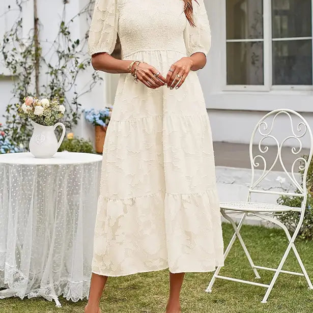 Cream-colored tiered midi dress featuring pleated puff sleeve and cutout detail