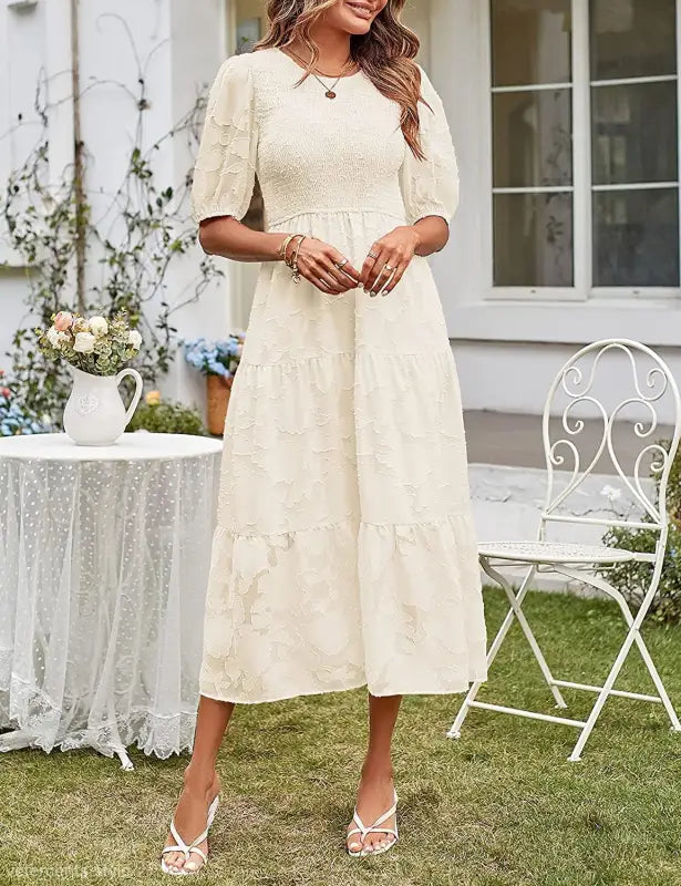 Cream-colored tiered midi dress featuring pleated puff sleeve and cutout detail