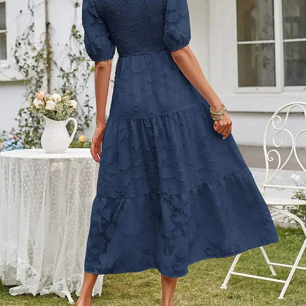 Navy blue tiered midi dress with pleated puff sleeve and elegant cutout detail
