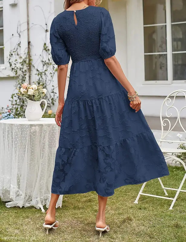 Navy blue tiered midi dress with pleated puff sleeve and elegant cutout detail