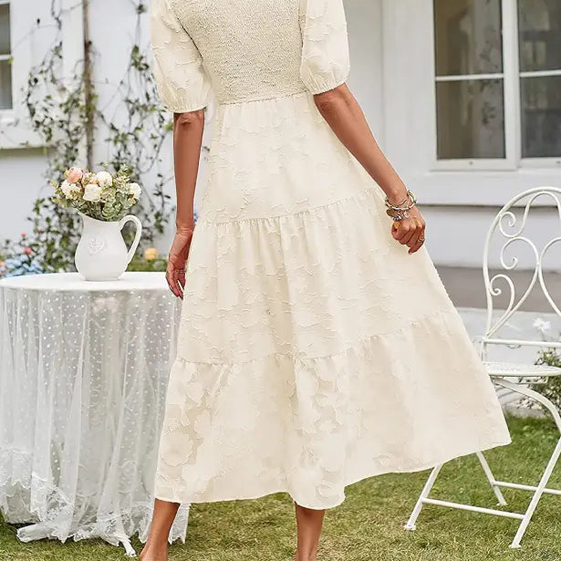Cream-colored textured midi dress featuring pleated puff sleeve and cutout detail