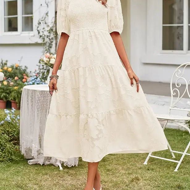 Cream-colored tiered midi dress featuring pleated puff sleeve and cutout detail