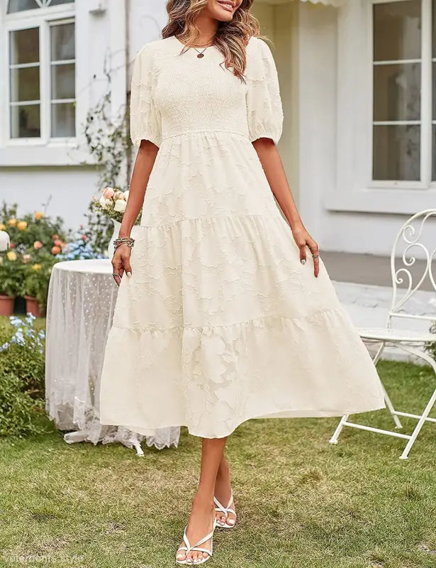 Cream-colored tiered midi dress featuring pleated puff sleeve and cutout detail