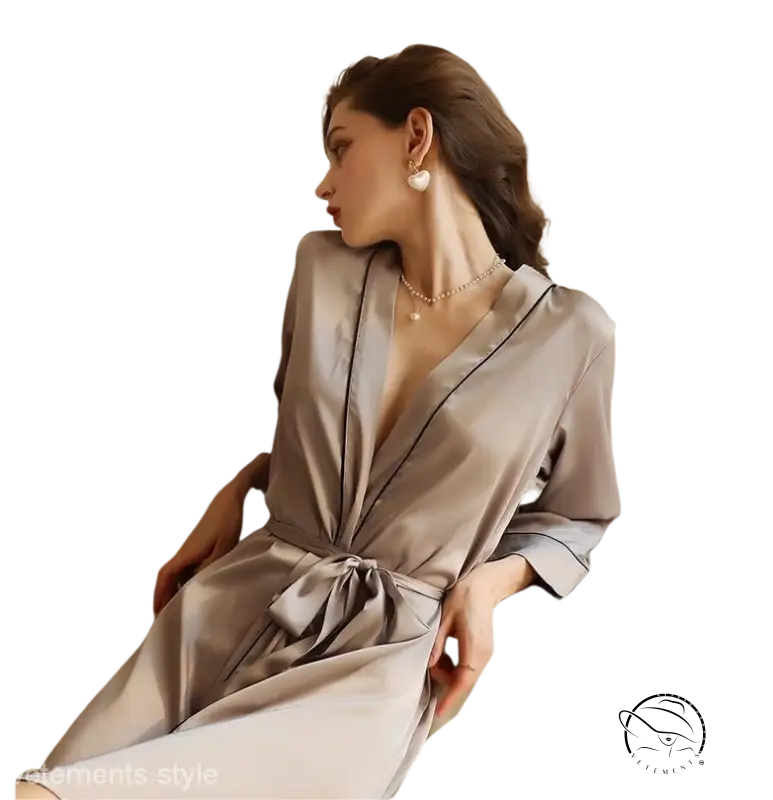 Woman in elegant midi silk pajamas with belted sleeves on bed