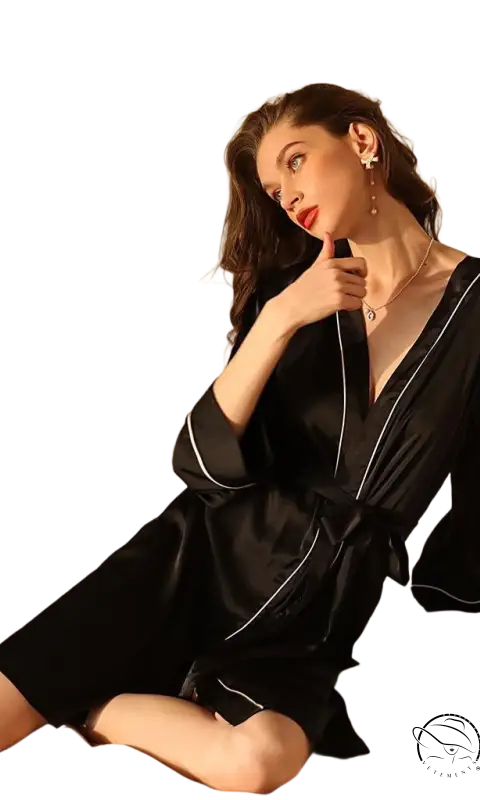 Woman in sexy midi silk pajamas with belted sleeves posing on bed