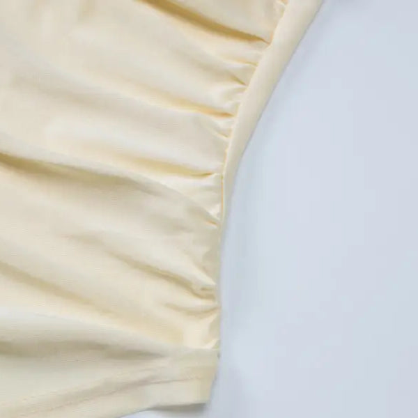 Cream-colored fabric with gathered or ruched texture along an edge.