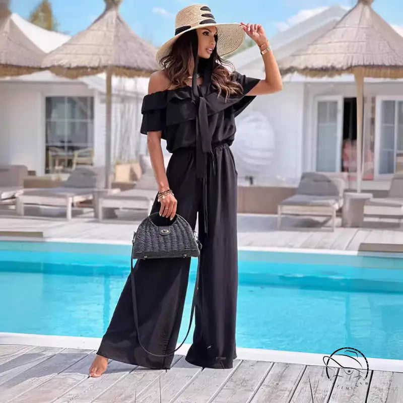 Woman in elegant off-shoulder ruffle jumpsuit with straw hat