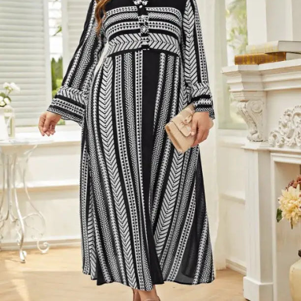 Black and white patterned maxi dress with long sleeves and artistic button waist