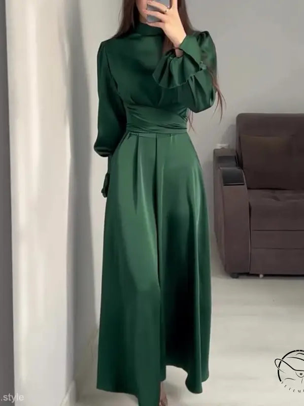 Elegant emerald green puff sleeve dress with a belted mock neck and cinched waist