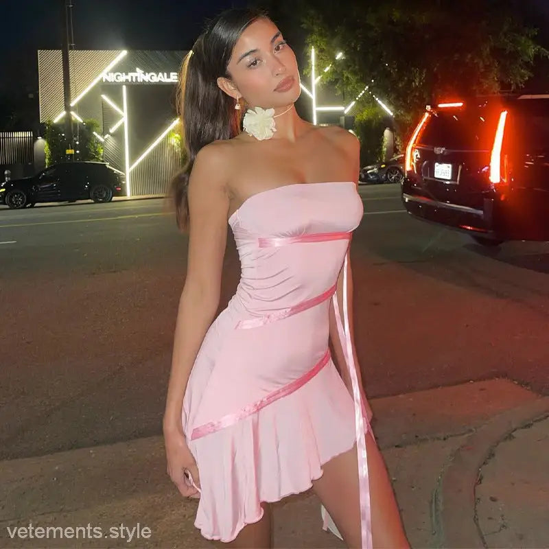 Woman in a strapless pink mini dress with ruffles and a flower, showcasing the Ribbon Ruffled Dress