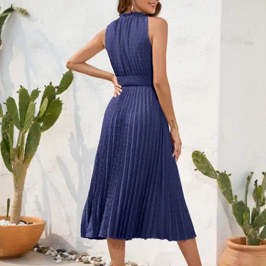 Woman in navy pleated maxi dress, a perfect vacation dress for summer weers